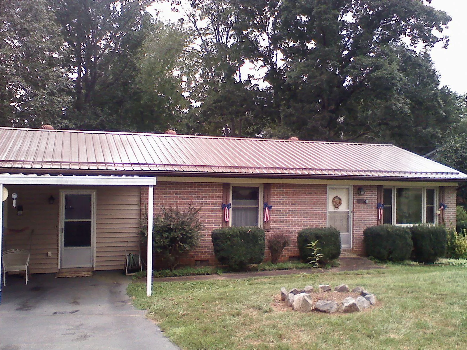 Bronze metal roof and carport on a brick ranch home — Roof Repair work by our crew in Dorchester
