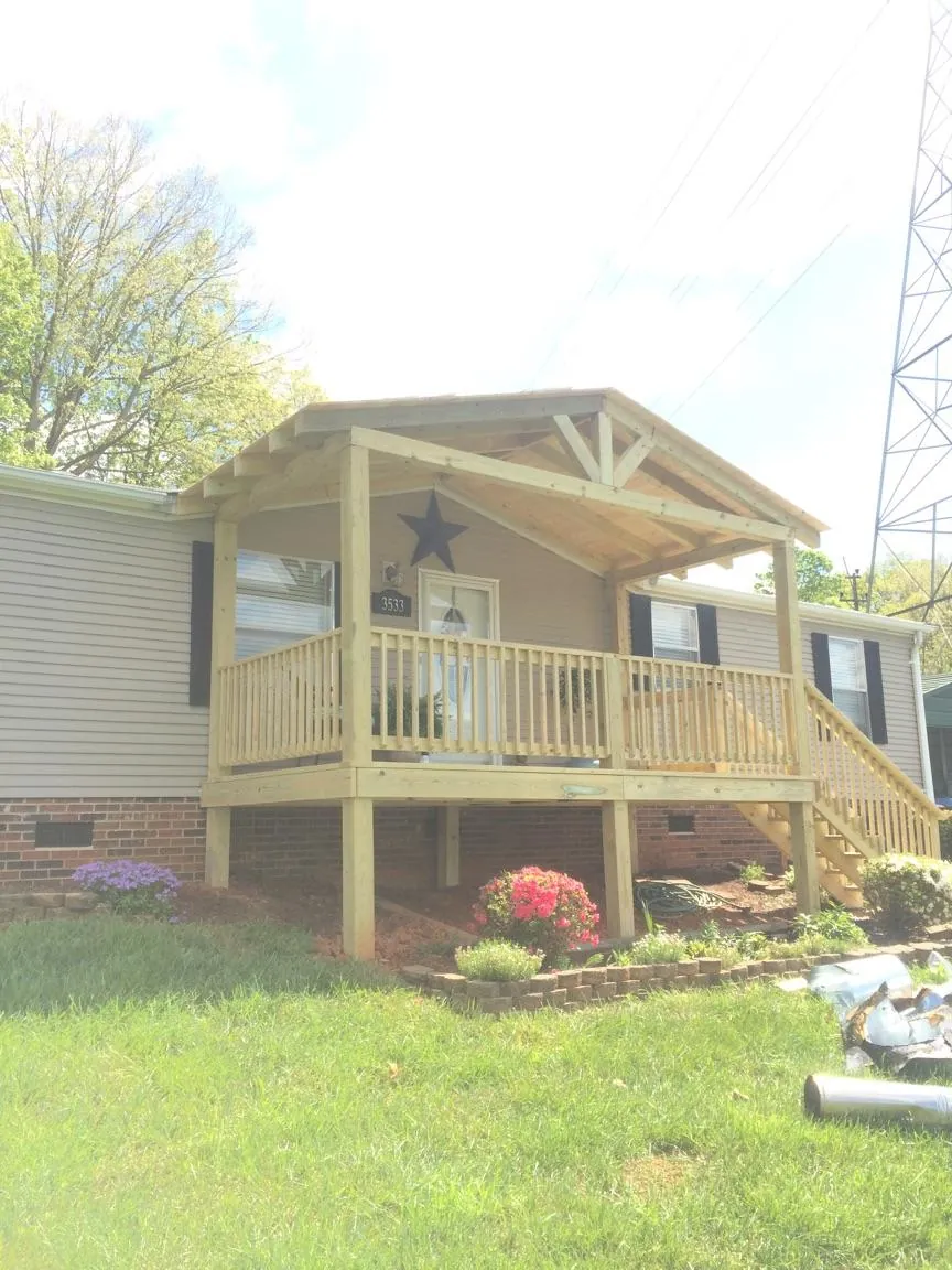 New gabled porch roof and deck railing added to a ranch home in Dorchester